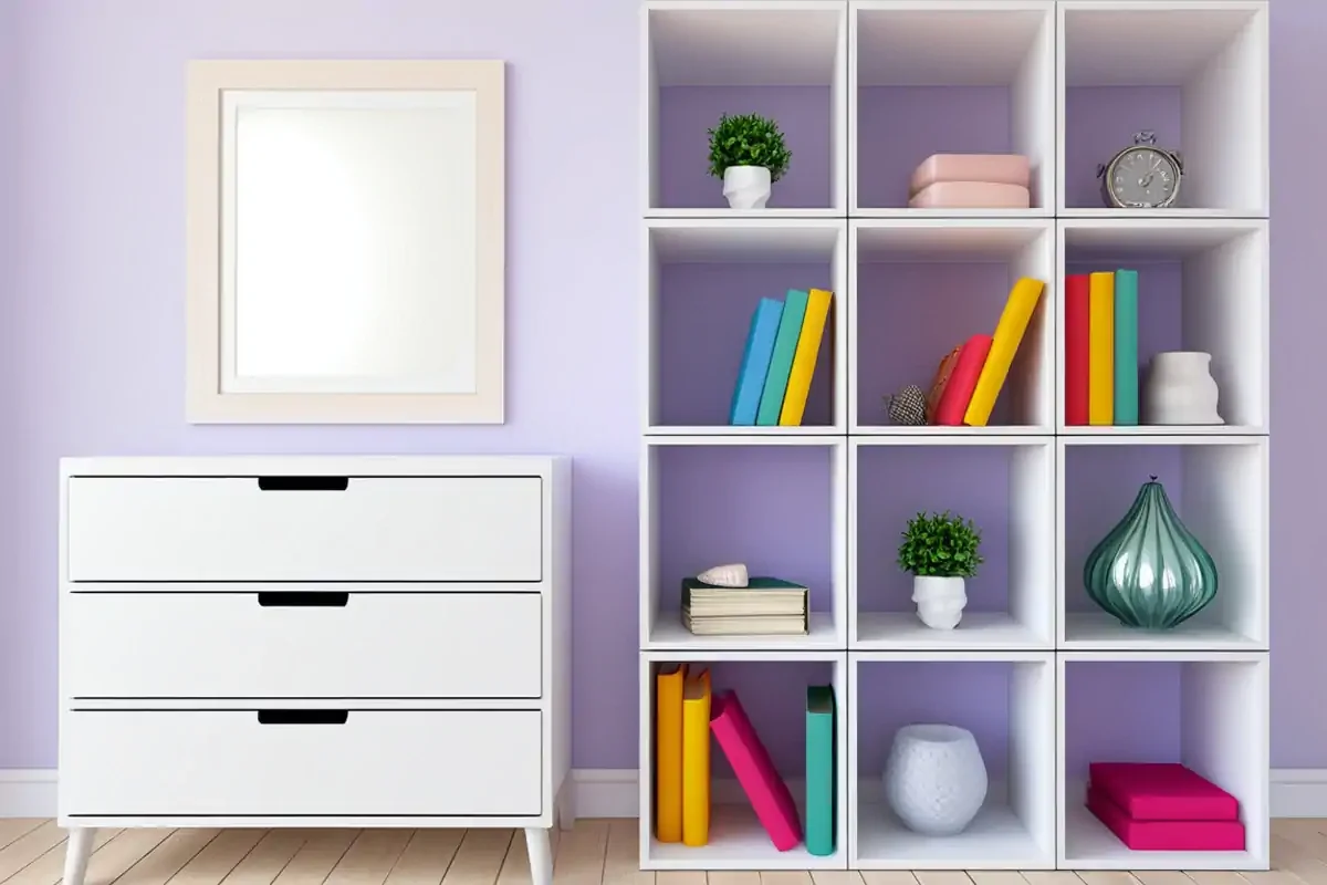 A tidy white cube storage shelf next to a white chest of drawers